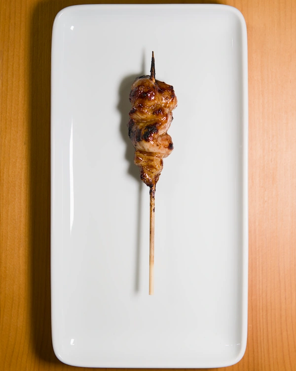 A yakitori skewer with chicken leg meat and covered in a tare sauce