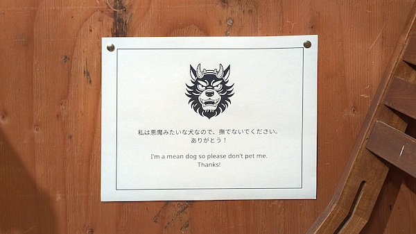 A sign with a dog illustration and japanese text