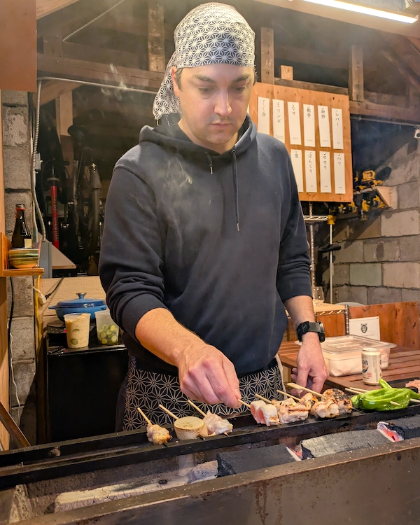 Person grilling skewers