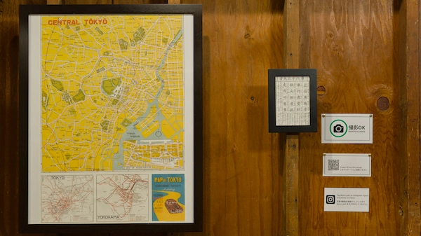 A vintage map of Tokyo on a wall along with some sings and a fortune
