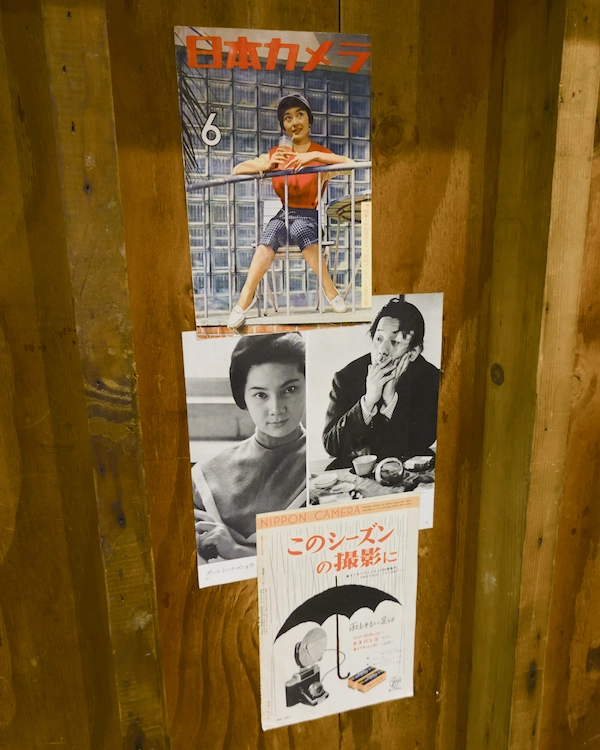 Pages from an old Japanese photography magazine pasted to a woodern wall